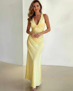 Elegant woman wearing the Lauven Solara Maxi Dress in yellow satin with sleeveless V-neck and A-line silhouette.