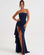 Model wearing Solenne Maxi Dress, a navy strapless dress with a high waist, side slit, and flowing asymmetric panel by Lauven.
