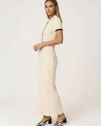 Side view of a woman wearing the Lauven Sorrento Maxi Dress in beige ribbed knit with collared button detail.