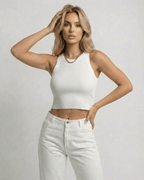 Model wearing Sorrento Top, a ribbed knit cropped sleeveless women’s white top by Lauven.