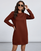 Woman wearing a Terra Mini Dress by Lauven, casual O neck long sleeve in rich brown shade, styled with sunglasses.