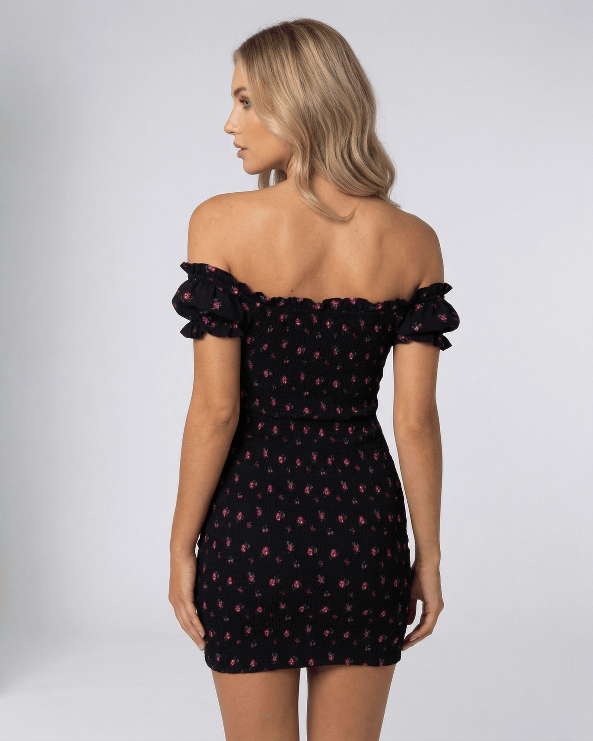 Valencia Mini Dress by Lauven, back view showcasing black floral off shoulder design and fitted silhouette.