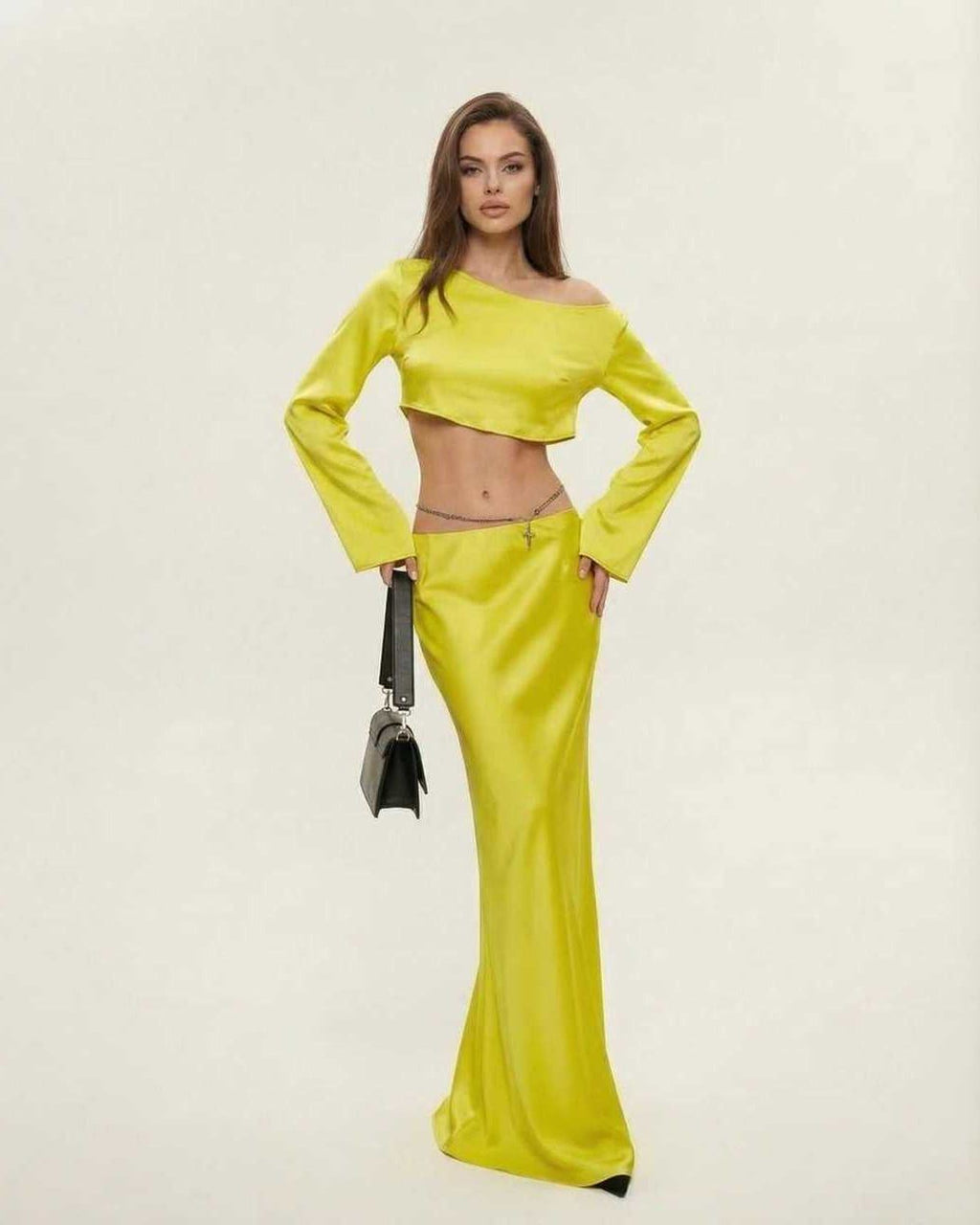 Model wearing the Vega Midi Dress by Lauven, showcasing vibrant yellow color and sleek asymmetrical design.
