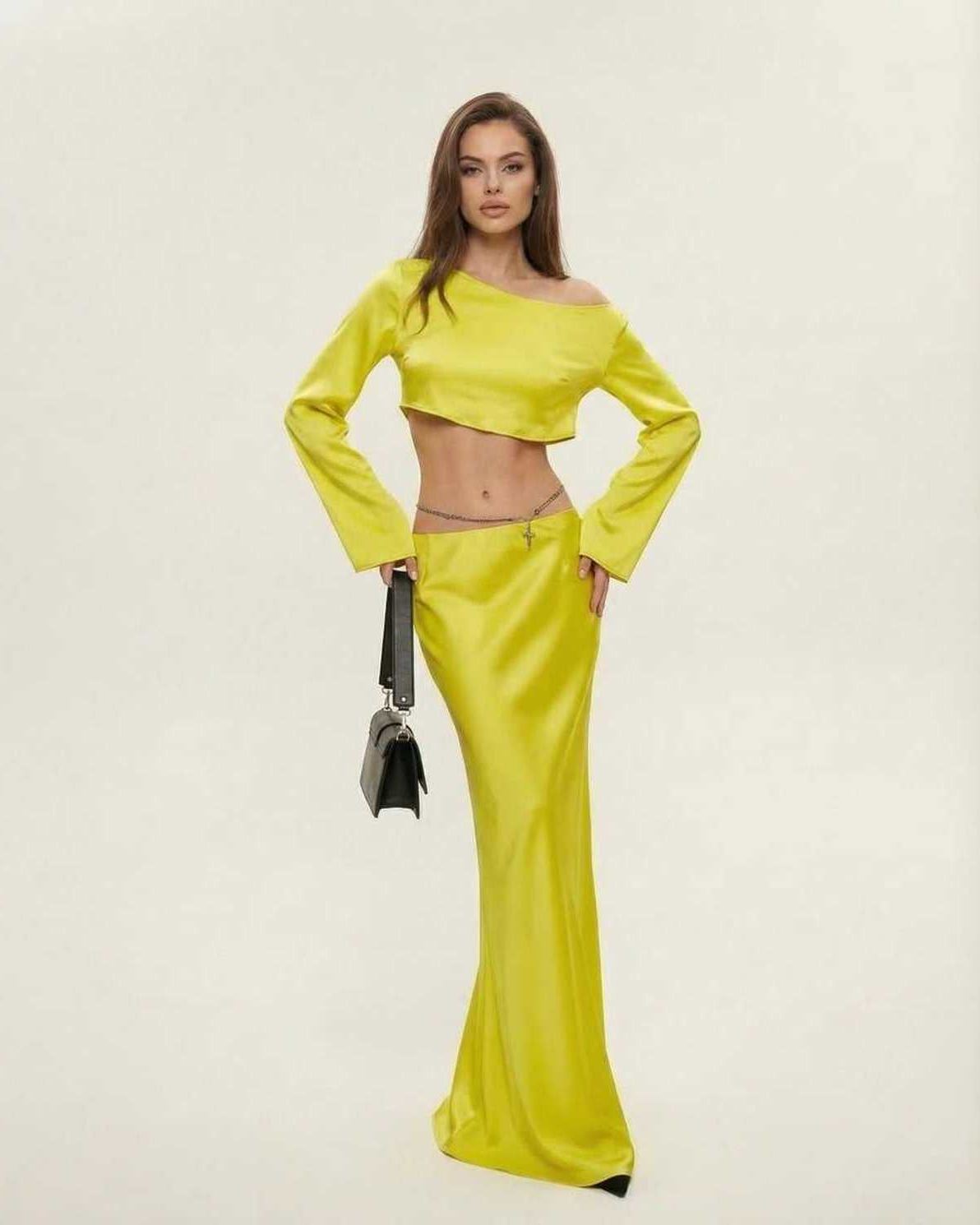 Model wearing the Vega Midi Dress by Lauven, showcasing vibrant yellow color and sleek asymmetrical design.