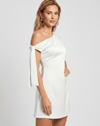 Veloura Mini Dress in white with asymmetric neckline and bow tie sleeves, soft satin finish by Lauven.