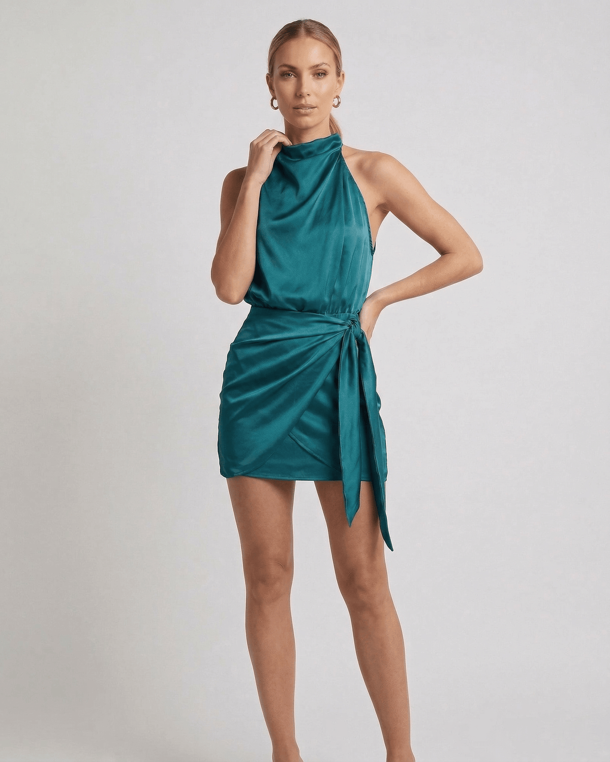 Verona Mini Dress by Lauven in emerald satin with high neck and wrap tie detail, showcasing modern elegance.
