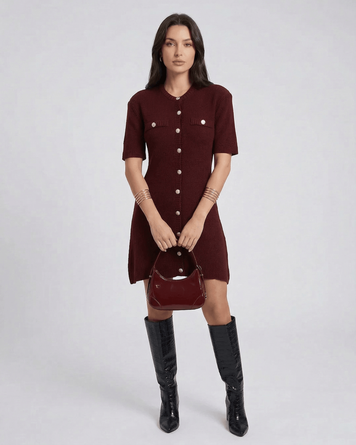 Model wearing Viera Mini Dress by Lauven in burgundy with button closure and stylish bag.
