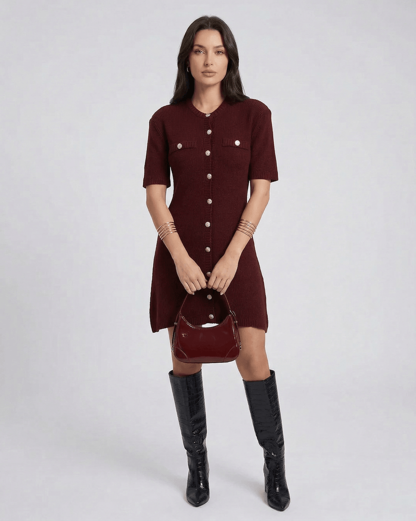 Model wearing Viera Mini Dress by Lauven in burgundy with button closure and stylish bag.