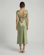 Virgo Midi Dress featuring a twisted-back and cutout detail in soft sage green, by Lauven. Elegant satin design.